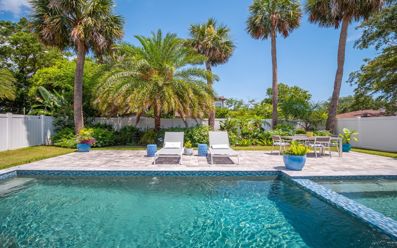 Luxury Home With Resort Style Pool Rear exterior of a modern home featuring a swimming pool, spa, and covered patio.