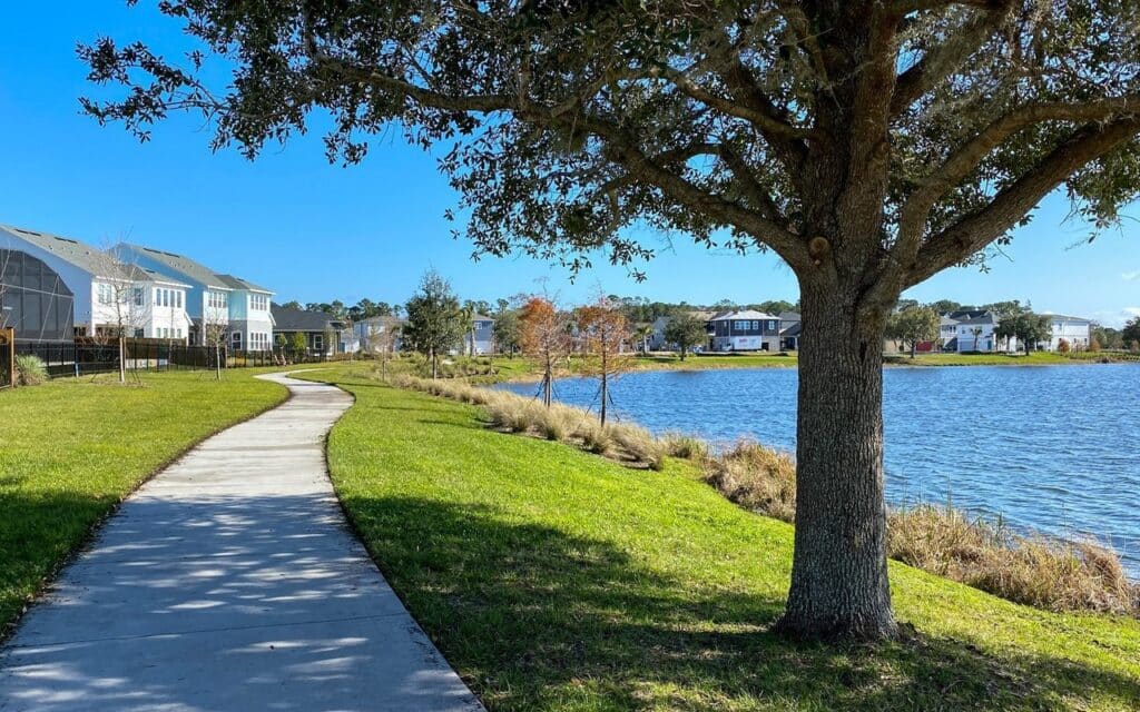 Lake_Nona_ Walking trail beside a peaceful lake with modern homes and scenic waterfront views in Lake Nona, FL